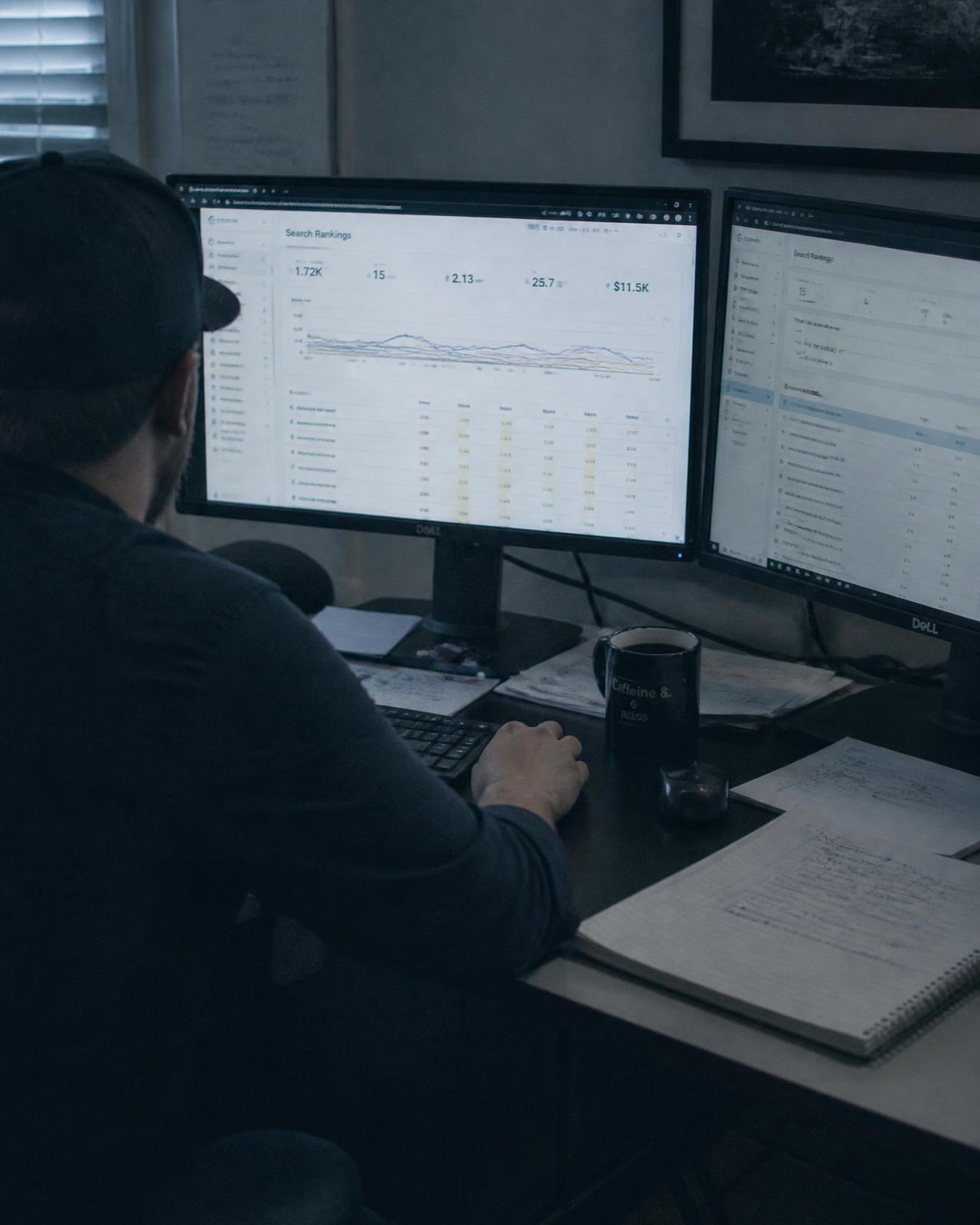 Specialist reviewing search ranking reports across two monitors